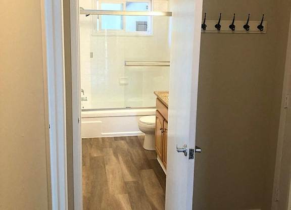 A white door is open to a bathroom with a toilet and sink.