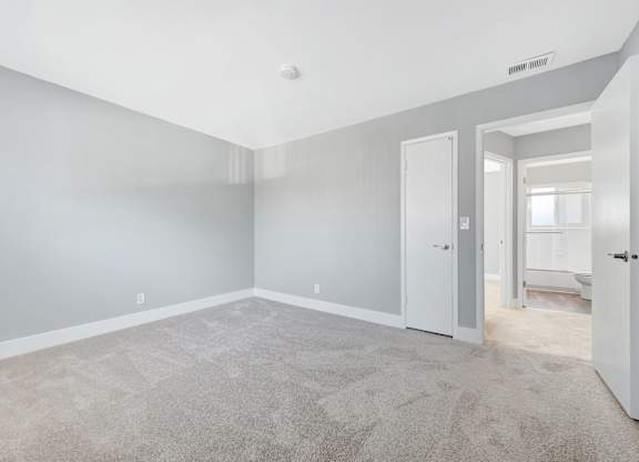 A spacious room with grey walls and carpeted floor.