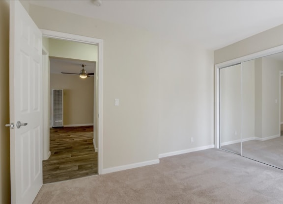 a bedroom with mirrored closet doors and a carpeted floor