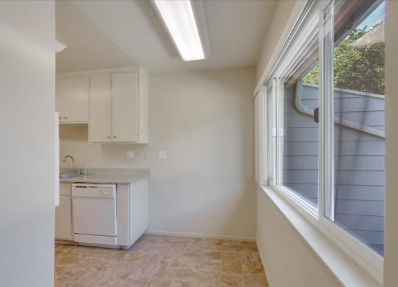 A kitchen with white cabinets and a washing machine.