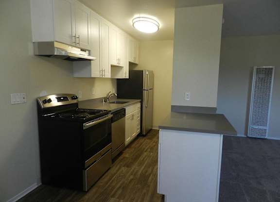 A kitchen with black appliances and white cabinets.