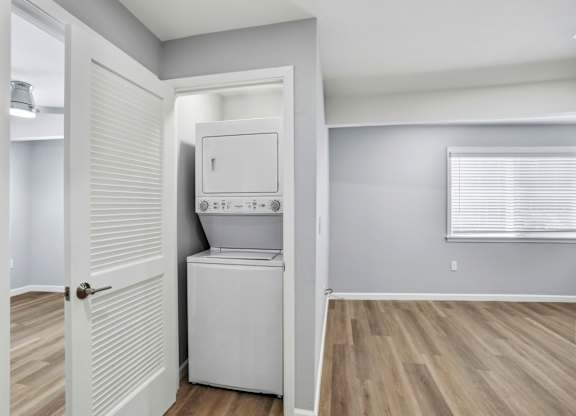 A white washer and dryer are in a small laundry room.