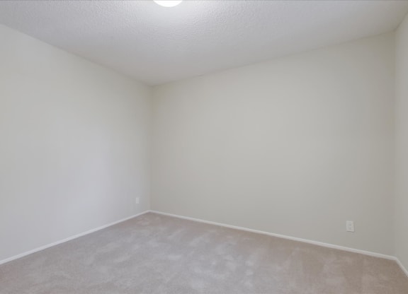 a empty room with white walls and carpet