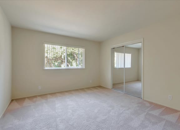 A room with a carpeted floor and a window.