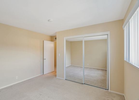 A room with a carpeted floor and a sliding glass door.