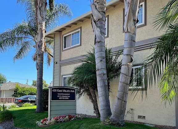 A building with a sign that says "Deer Park Apartments" in front of it.