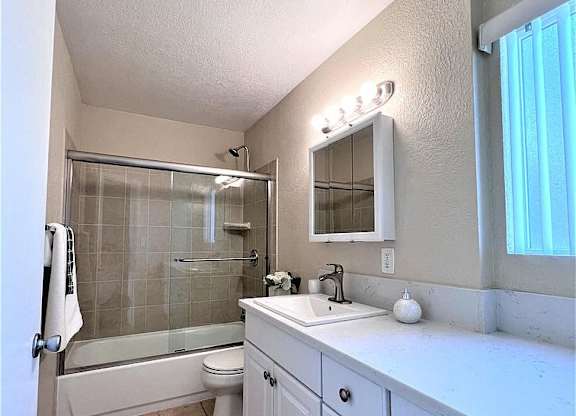 A bathroom with a white sink and a white toilet.