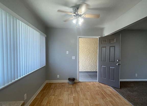 a living room with a wood floor and a ceiling fan