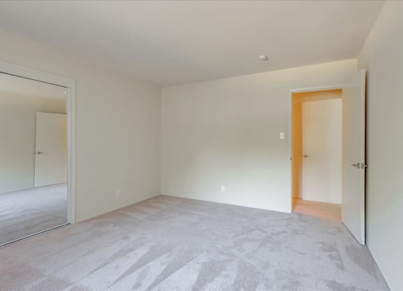 A room with a carpeted floor and a wooden door.