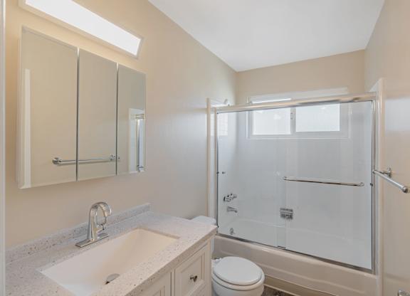 A bathroom with a sink, toilet, and shower.