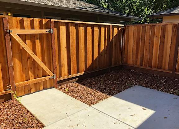 A wooden fence with a gate in the middle.