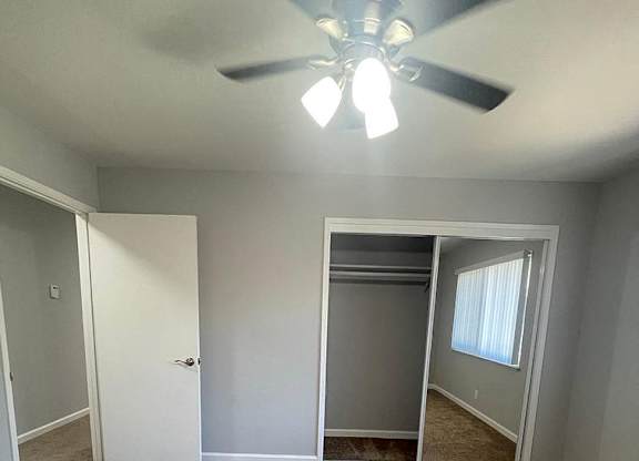 an empty living room with a ceiling fan