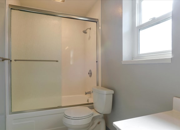 a white bathroom with a shower and a toilet