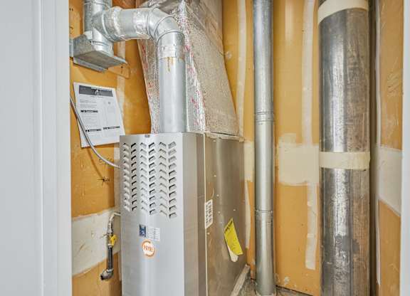 A wall with pipes and a ventilation system.