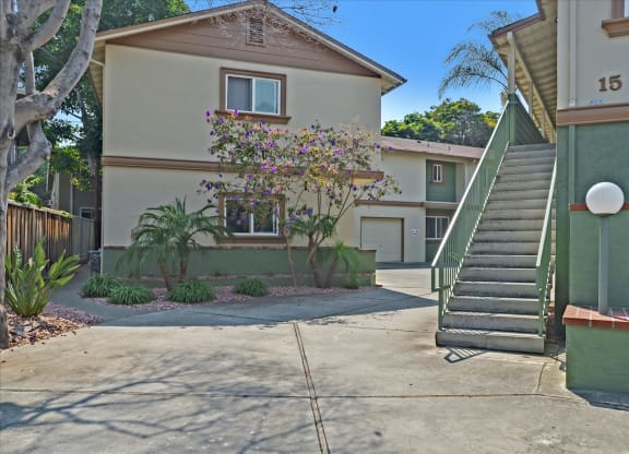 a driveway in front of a house with a staircase