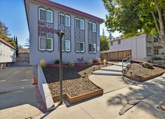 a building with stairs and a sidewalk in front of it