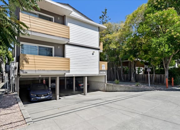 an apartment building with a car parked in a driveway