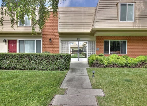 a sidewalk in front of a brick house