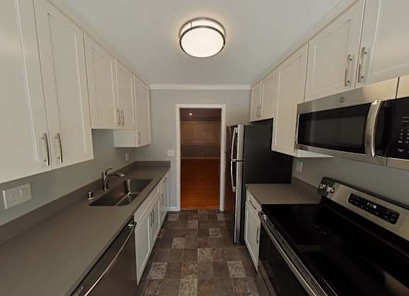 A kitchen with black appliances and white cabinets.