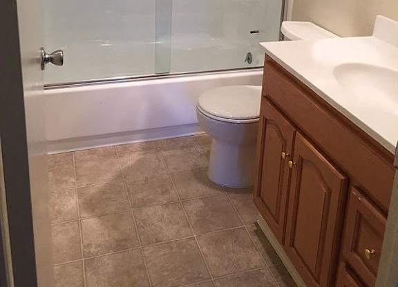 A white toilet sits in a bathroom next to a walk-in shower.