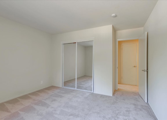 A room with a carpeted floor and a door on the right.