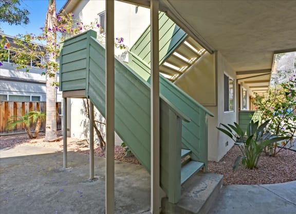 the entrance to a building with green siding and stairs