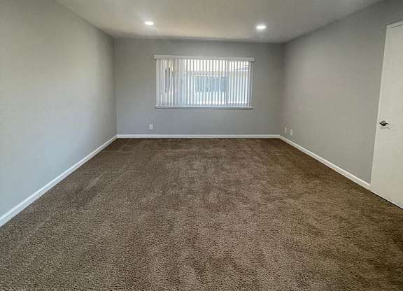 an empty room with carpet and a window