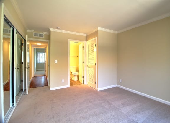 A room with a carpeted floor and a doorway leading to another room.