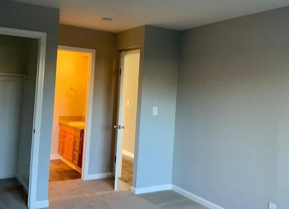 A room with a carpeted floor and a doorway leading to another room.