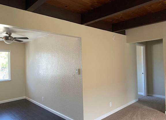 a empty room with a ceiling fan and a door