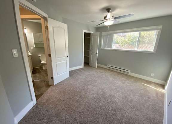 A room with a ceiling fan and a window.