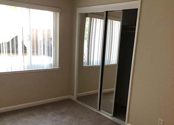 A room with a carpeted floor and a sliding glass door.
