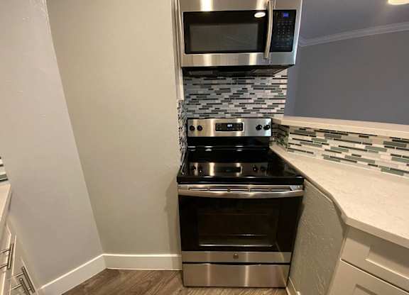 A modern kitchen with a stainless steel oven and microwave.