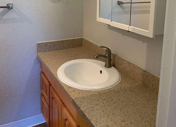 A bathroom with a sink and a mirror.