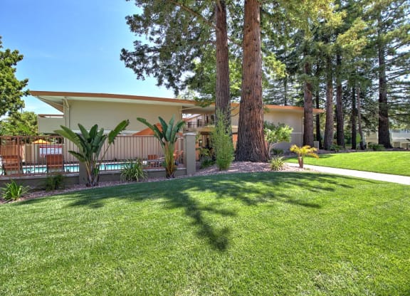 A house with a white roof and a green lawn in front.