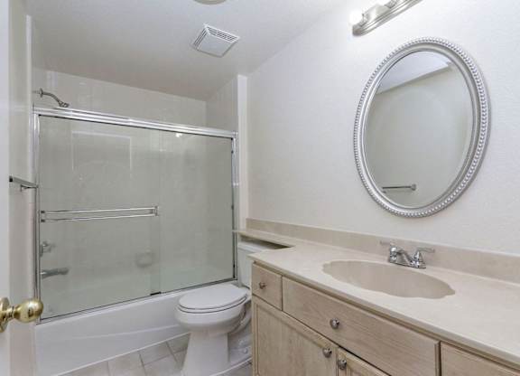 A bathroom with a toilet, sink, and shower.