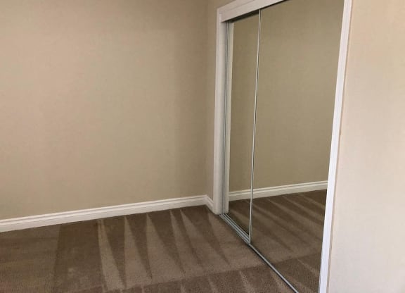 a closet with a pair of mirrored closet doors