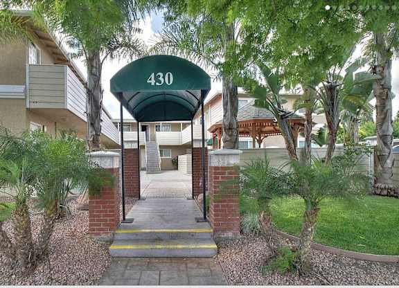 The entrance to apartment 430 is framed by a green awning and bordered by a brick wall.