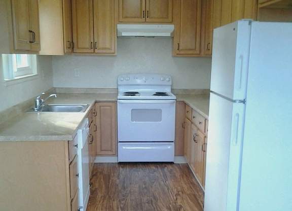 A kitchen with wooden cabinets and a white refrigerator.
