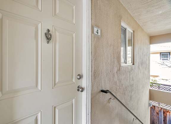 A white door with a silver handle and a number 4 on the wall.