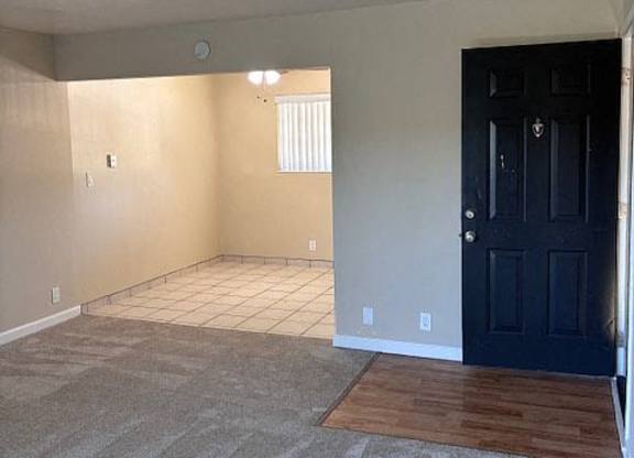 A room with a black door and a window with blinds.