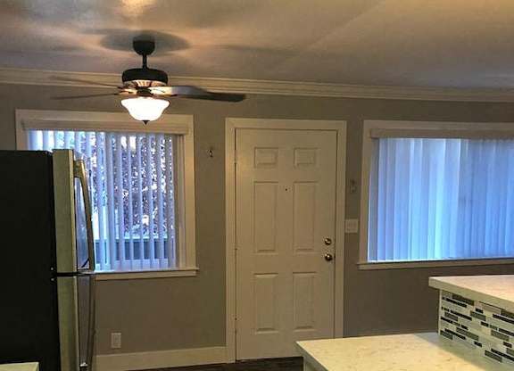 A kitchen with a black fridge and white cabinets.
