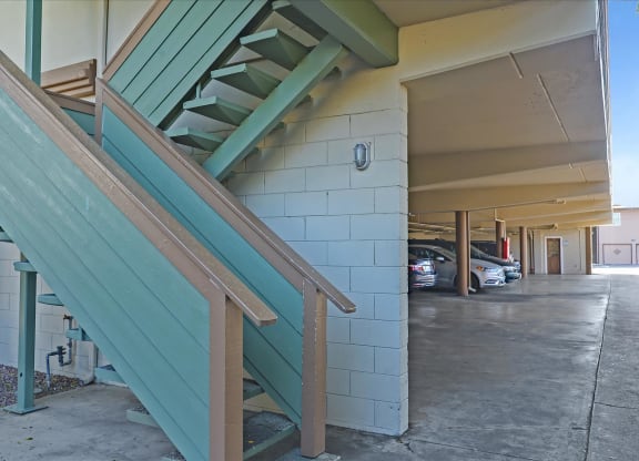 A green staircase with wooden handrails.