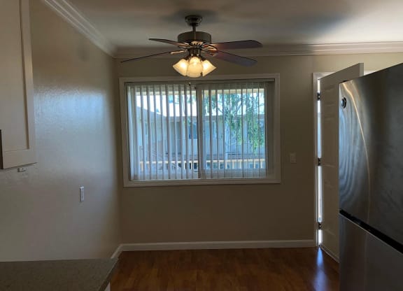 a living room with a large window and a ceiling fan
