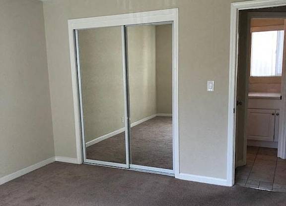 A room with a sliding door and carpeted floor.