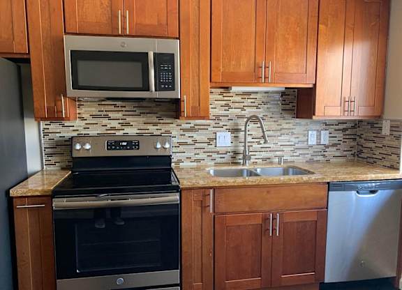 a kitchen with stainless steel appliances and wooden cabinets