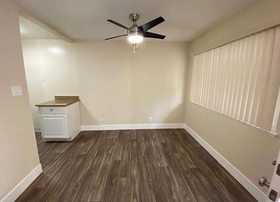 a living room with wood floors and a ceiling fan