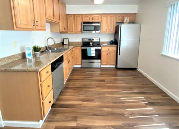 a kitchen with wood floors and wooden cabinets