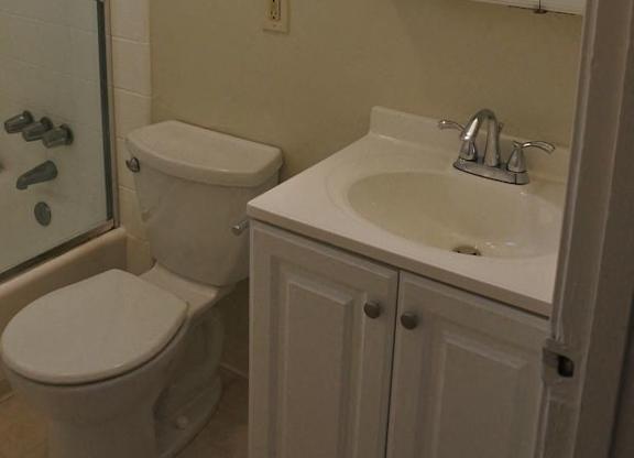 A white toilet and sink in a bathroom.