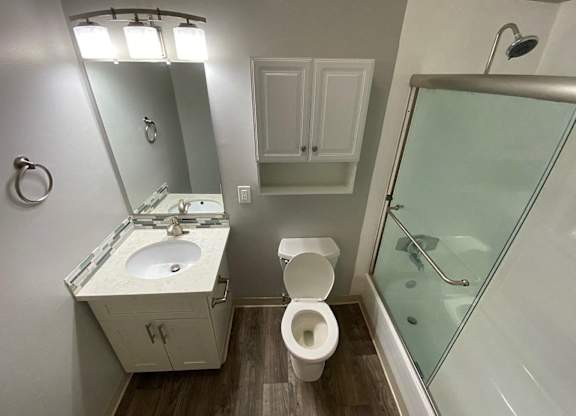 A bathroom with a toilet, sink, and shower.